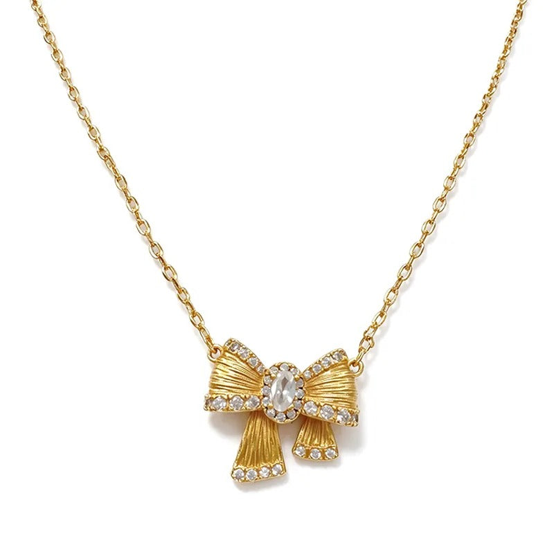 Close-up of the brushed gold bow pendant and its centre stone