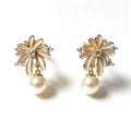 Gold pearl stud earrings with a ray-set burst